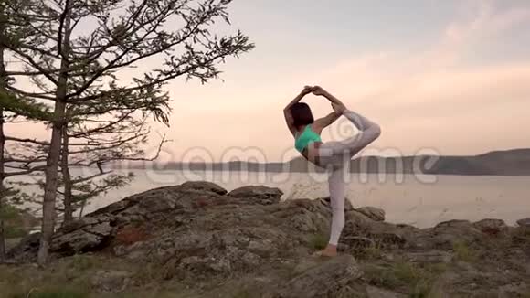 一个年轻漂亮的女孩在海边做瑜伽风景优美全景拍摄视频的预览图