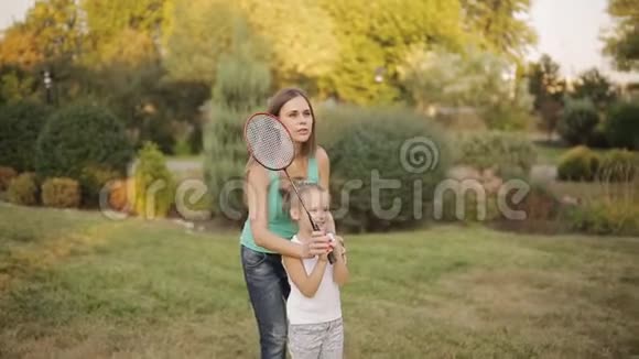 妈妈教小女儿打羽毛球积极的家庭假期视频的预览图