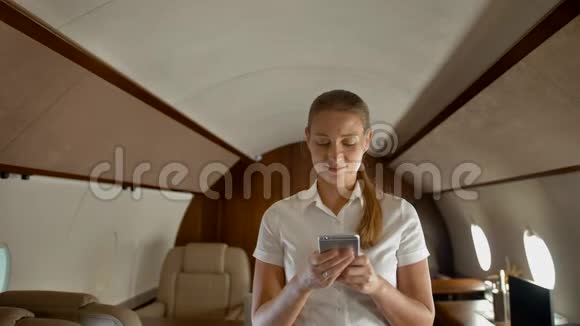 忙碌的年轻女性在智能手机上用私人飞机打字视频的预览图