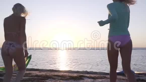 三个年轻的女人跑到海滩开始摆姿势日落视频的预览图