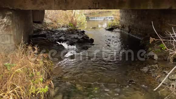 这条河流在一座小混凝土桥下视频的预览图