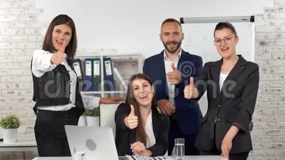 团体微笑的商务人士穿着西装在现代化的光线办公室背景下展示着酷酷的姿态视频的预览图