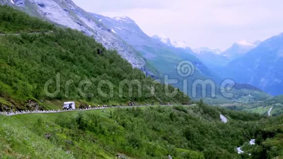 陡峭的山区公路一群骑自行车的人骑着自行车下山路上还有其他交通视频的预览图