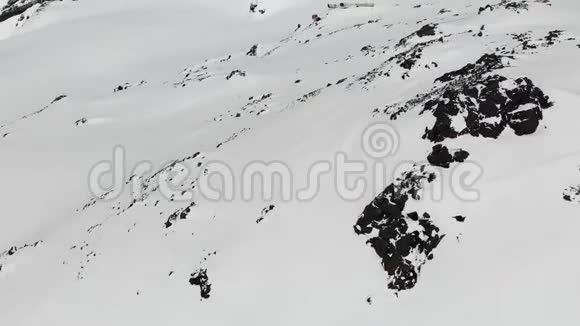 鸟瞰冬山景观Bivuak酒店位于南部度假胜地积雪覆盖的岩石斜坡上视频的预览图