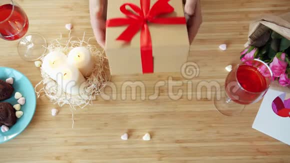 晚餐时男人在礼品盒中向咖啡馆里的女人送礼物的缓慢动作视频的预览图