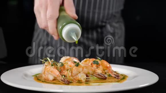 在餐厅的白色盘子上将刚准备好的大虾排成一排倒入绿色酱汁慢慢视频的预览图
