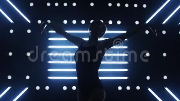 女孩在黑暗的房间里跳舞跳着性感的舞蹈从后面发光视频的预览图