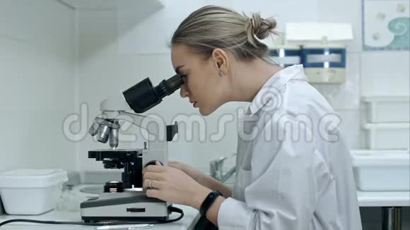 一位在实验室用显微镜工作的吃惊女人视频的预览图