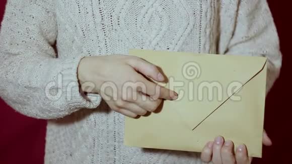 美丽的女孩打开她的礼物漂亮女孩的手打开礼物信封假期的礼物视频的预览图