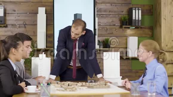 商务套装建筑师靠在桌子前视频的预览图