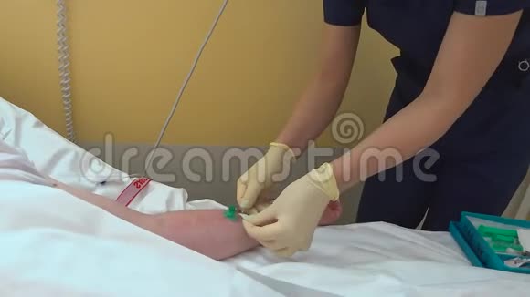 身份不明的蒙面护士在病人手臂上固定静脉导管视频的预览图
