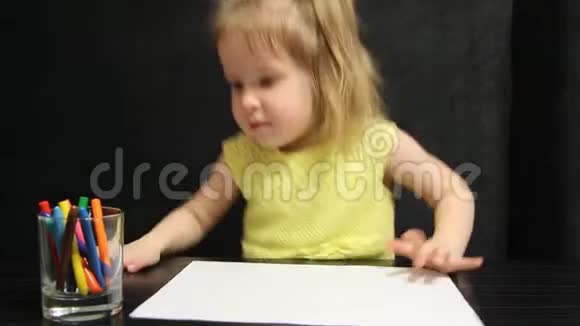 小女孩拿起彩色铅笔在黄色T恤里画画视频的预览图