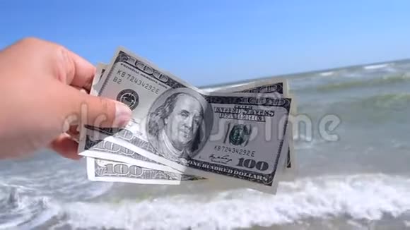 大海背景下300美元钞票的女孩视频的预览图