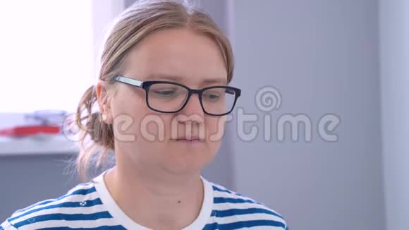 一个戴透明眼镜的女人微笑着看着温度计视频的预览图
