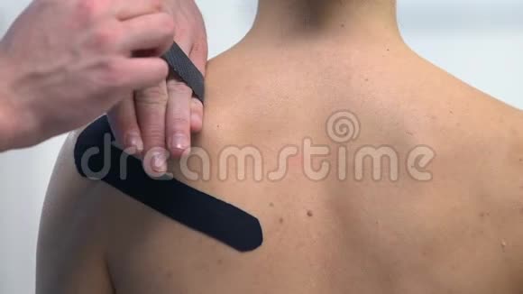 治疗师在女性肩部应用Y形胶带运动创伤肌肉疼痛视频的预览图