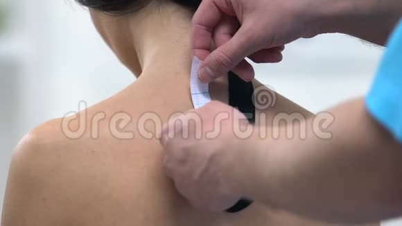 医生给女性上背部用Y形胶带减少肌肉紧张视频的预览图