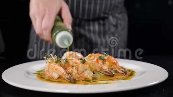意大利菜厨师在放在白色盘子上的虾菜上浇酱汁美味可口的自制菜肴视频的预览图