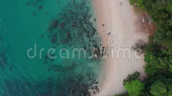 带绿松石海水和岩石的热带空海滩的俯视图视频的预览图