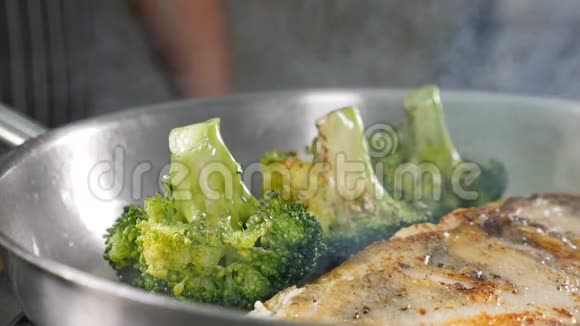 在煎锅上用蔬菜煮鱼片时火火焰和油会缓慢地溅出餐厅视频的预览图