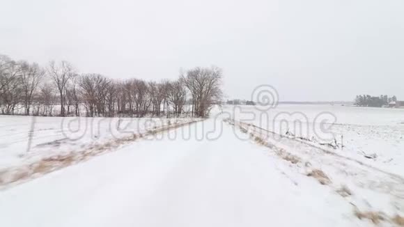 沿着中西部一条下雪的乡村公路行驶视频的预览图