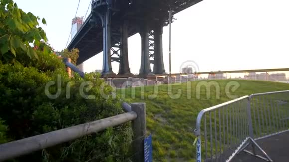 慢动作从美国纽约市布鲁克林大桥下看阳光明媚的一天绿草如茵阳光明媚视频的预览图