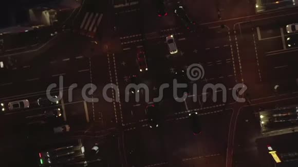 空中美丽的头顶拍摄的繁忙路口在夜间与汽车交通和城市灯视频的预览图
