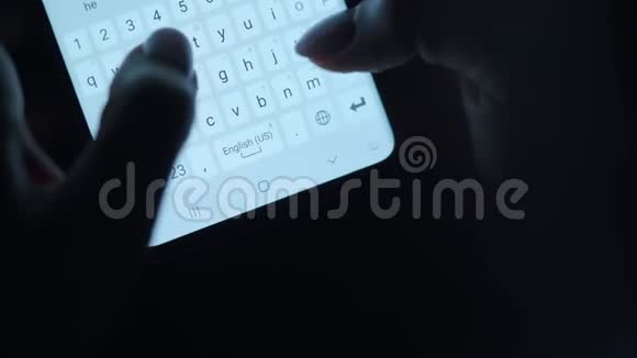 双手在智能手机特写上键入文本晚上用智能手机关门视频的预览图