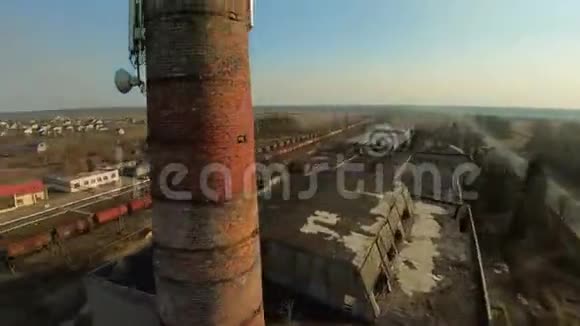 在日落时FPV无人驾驶飞机带着接收器在塔周围飞行旧废弃工厂视频的预览图