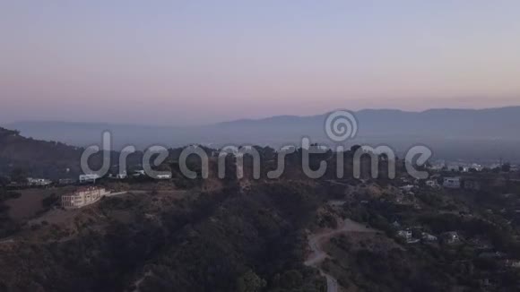 艾琳在日出的好莱坞山上可以看到山丘山谷和洛杉矶的电力线视频的预览图