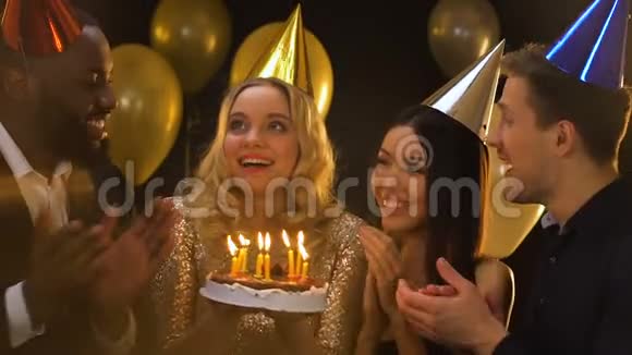 戴着b日帽的白人女人在蛋糕上吹蜡烛庆祝视频的预览图