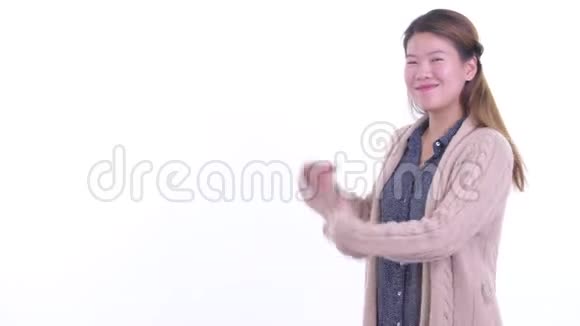 快乐的年轻亚洲女人展示回来准备过冬视频的预览图