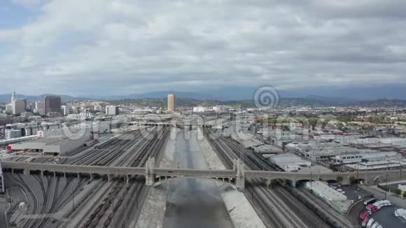 洛杉矶河与水在云层笼罩的天空旁边的火车轨道视频的预览图