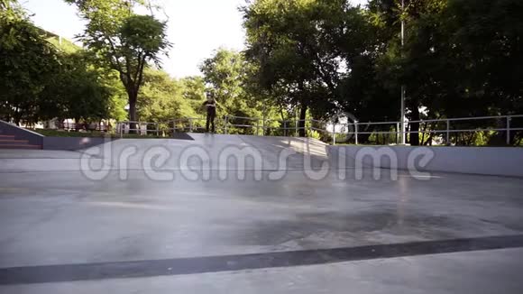在公共滑板公园的斜道上穿着休闲服的懒汉骑着内排滑轮滑冰鞋跳起来挂起来视频的预览图