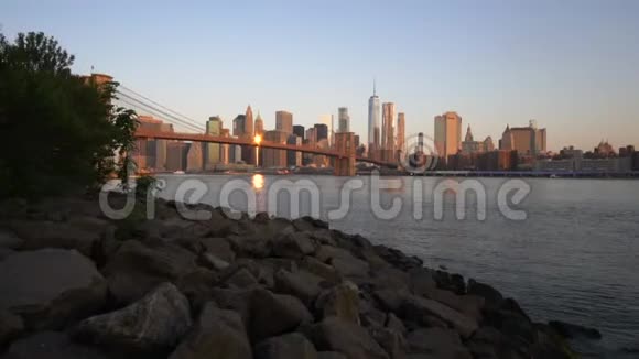 曼哈顿市中心景观靠近水布鲁克林大桥在美丽的日出阳光在夏季水上午视频的预览图