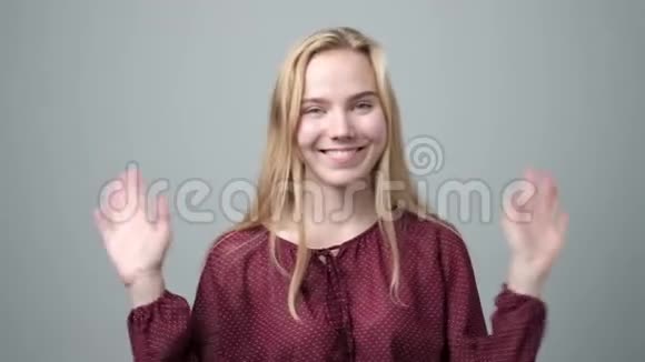 年轻的白种人金发女人挥舞着手欢迎她的朋友视频的预览图