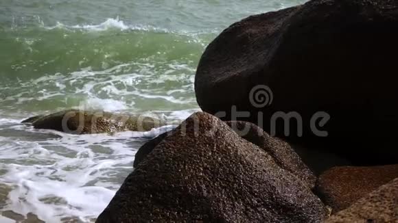 站在海洋中的大岩石的海浪拍击视频的预览图
