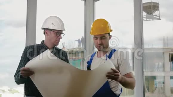 工程师和建筑工人讨论一份蓝图视频的预览图