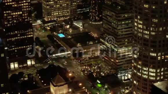 美国银行大厦的近景摩天大楼的脚和洛杉矶市中心加州的夜晚发光的城市视频的预览图