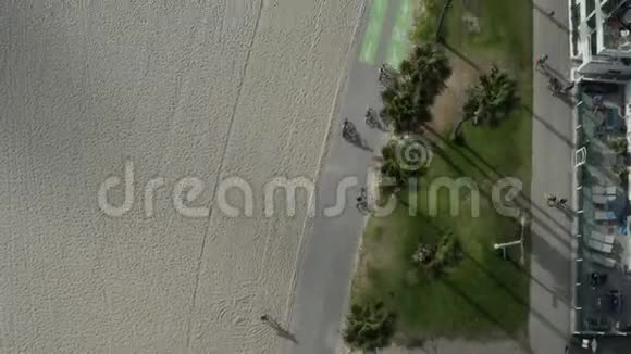鸟瞰飞行从威尼斯海滩木板步行棕榈树和自行车道阳光加州洛杉矶视频的预览图