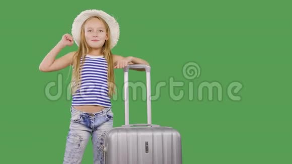 旅游女孩用手打招呼并在绿色背景上交谈带手提箱的少女视频的预览图