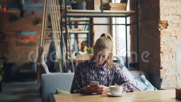 快乐的年轻女士使用智能手机然后使用设备在线支付咖啡馆费用视频的预览图