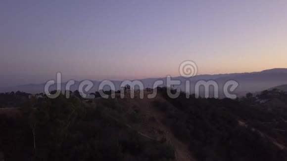 空中在日出的好莱坞山上可以看到山丘和洛杉矶山谷的景色视频的预览图
