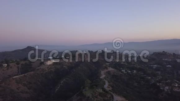 空中在日出的好莱坞山上可以看到山丘山谷和洛杉矶的电力线路视频的预览图