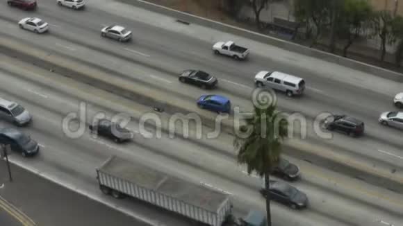 艾琳看看高速公路然后倾斜到加州洛杉矶市中心有棕榈树多云视频的预览图