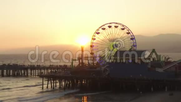 阿里亚在美丽的日落时分靠近圣莫尼卡码头弗赖斯轮与游客行人一起观看洛杉矶美丽的日落视频的预览图