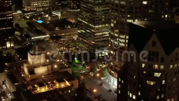 美国银行大厦的近景摩天大楼的脚和洛杉矶市中心加州的夜晚发光的城市视频的预览图
