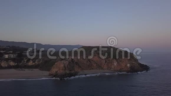 飞机从加州马里布岛上空飞行可在日落时看到海滩海岸线和山崖视频的预览图