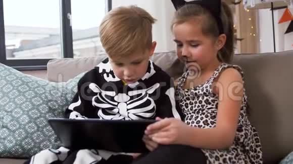 孩子们在家里穿着带有平板电脑的万圣节服装视频的预览图