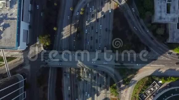 鸟瞰洛杉矶市中心加利福尼亚与棕榈树和天际线蓝天相交的交通视频的预览图