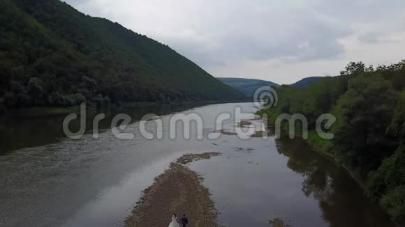 空中观景新娘新郎喀尔巴阡山上的河流视频的预览图